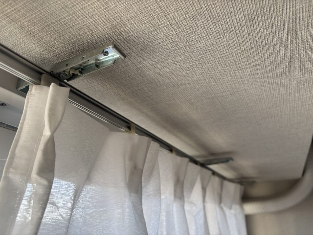 既存のI型カーテンレールを撤去した後の壁に残ったネジ穴。賃貸物件の原状回復のため大切に保管。