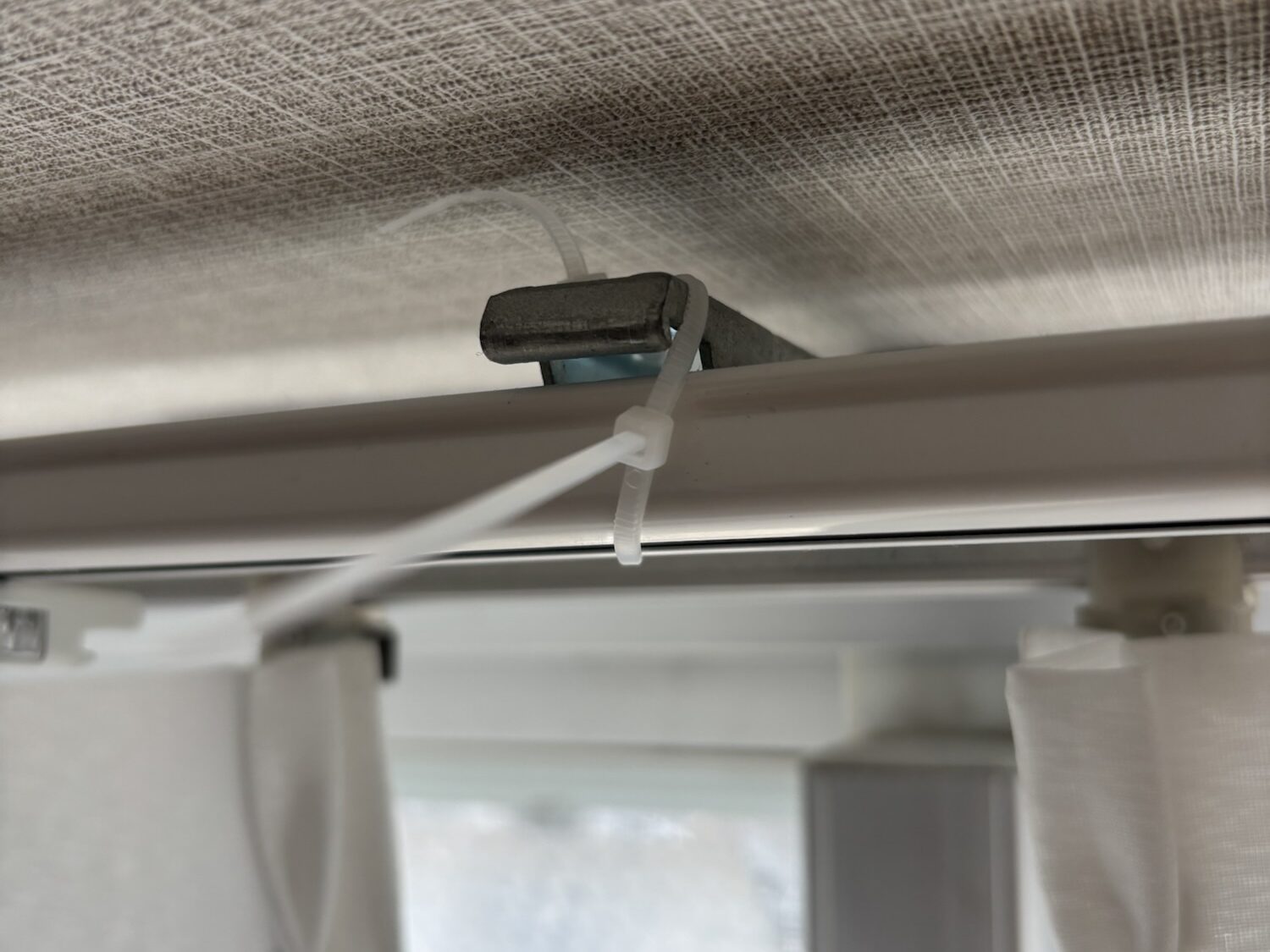 ニトリの角型カーテンレールにハニカムシェード用コネクターをスムーズに差し込んでいる様子。